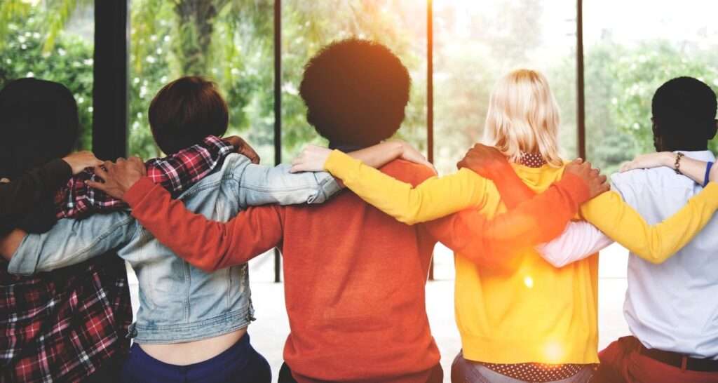 5 Kids Embracing Each Other And Fill With Joy And Happiness In Front Of A Day Light